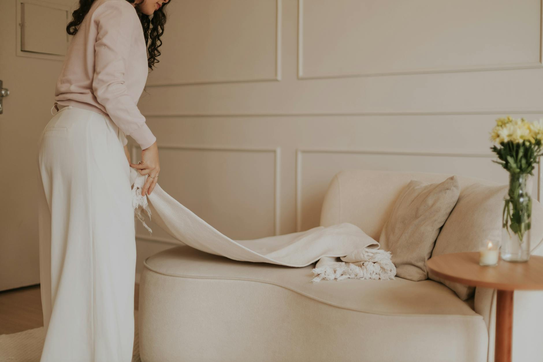 Jasny, minimalistyczny salon z sofą i dużym oknem w stonowanych barwach