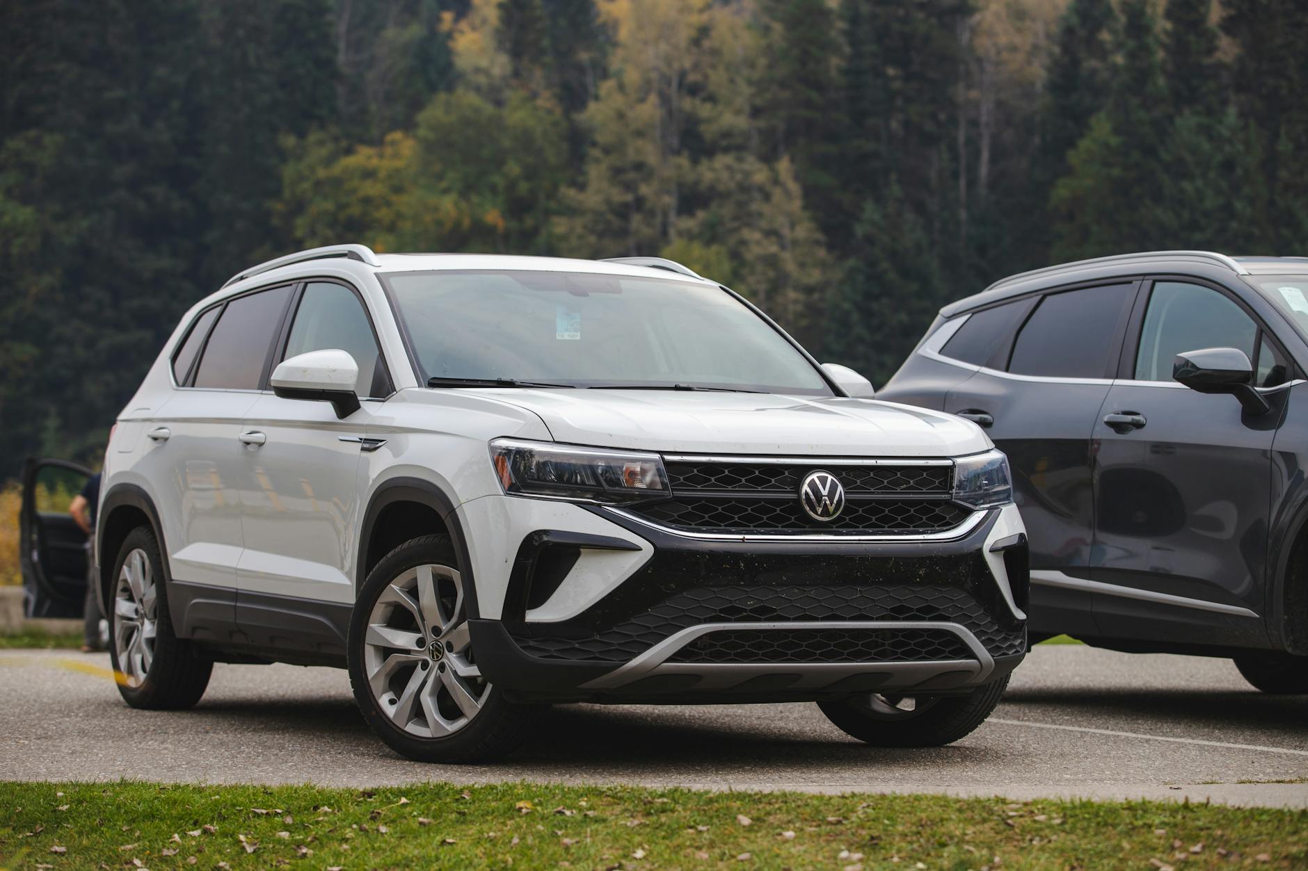 Biały SUV Volkswagen zaparkowany w lesie na tle drzew