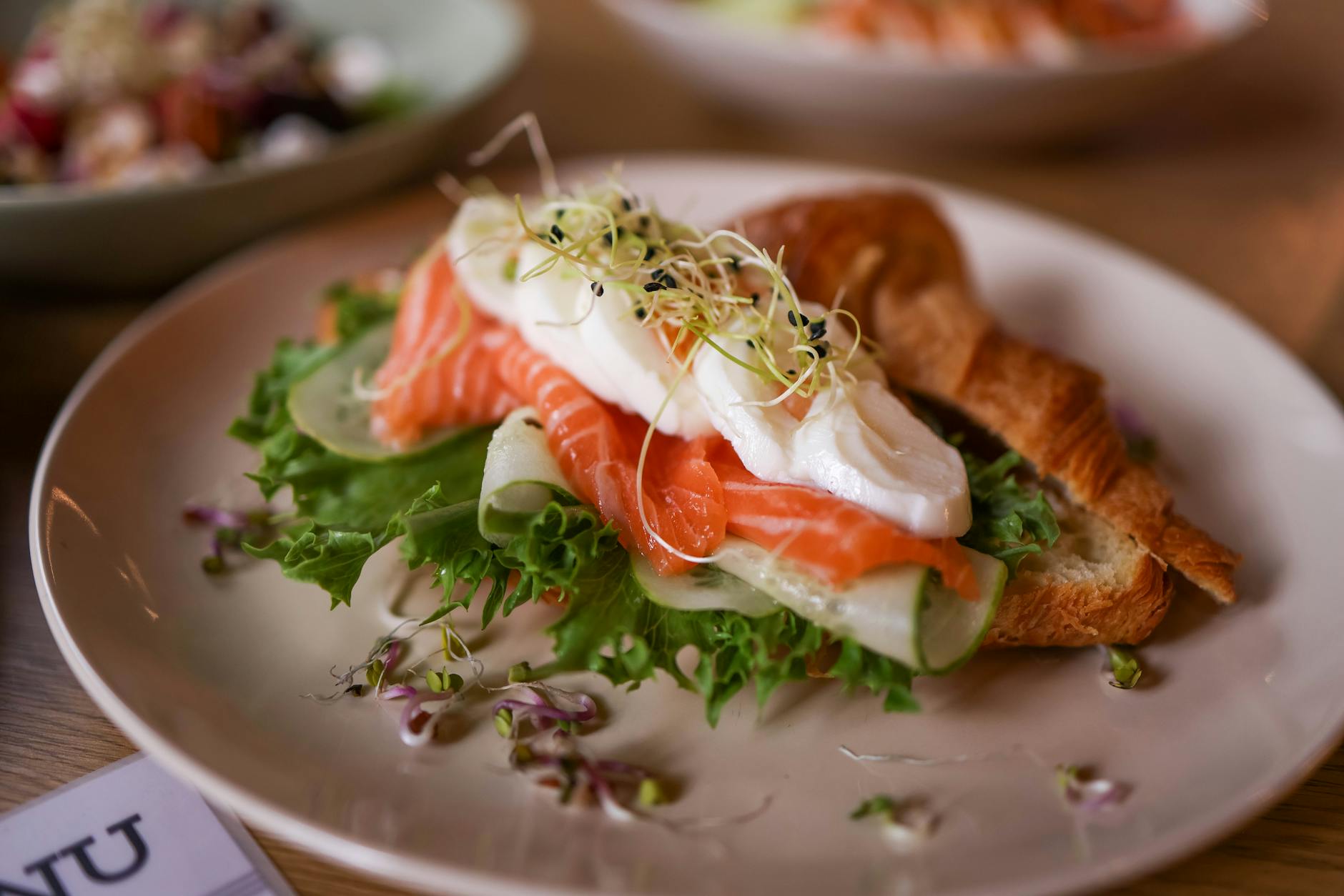 Croissant z łososiem, jajkiem w koszulce i sałatą jako lekki lunch