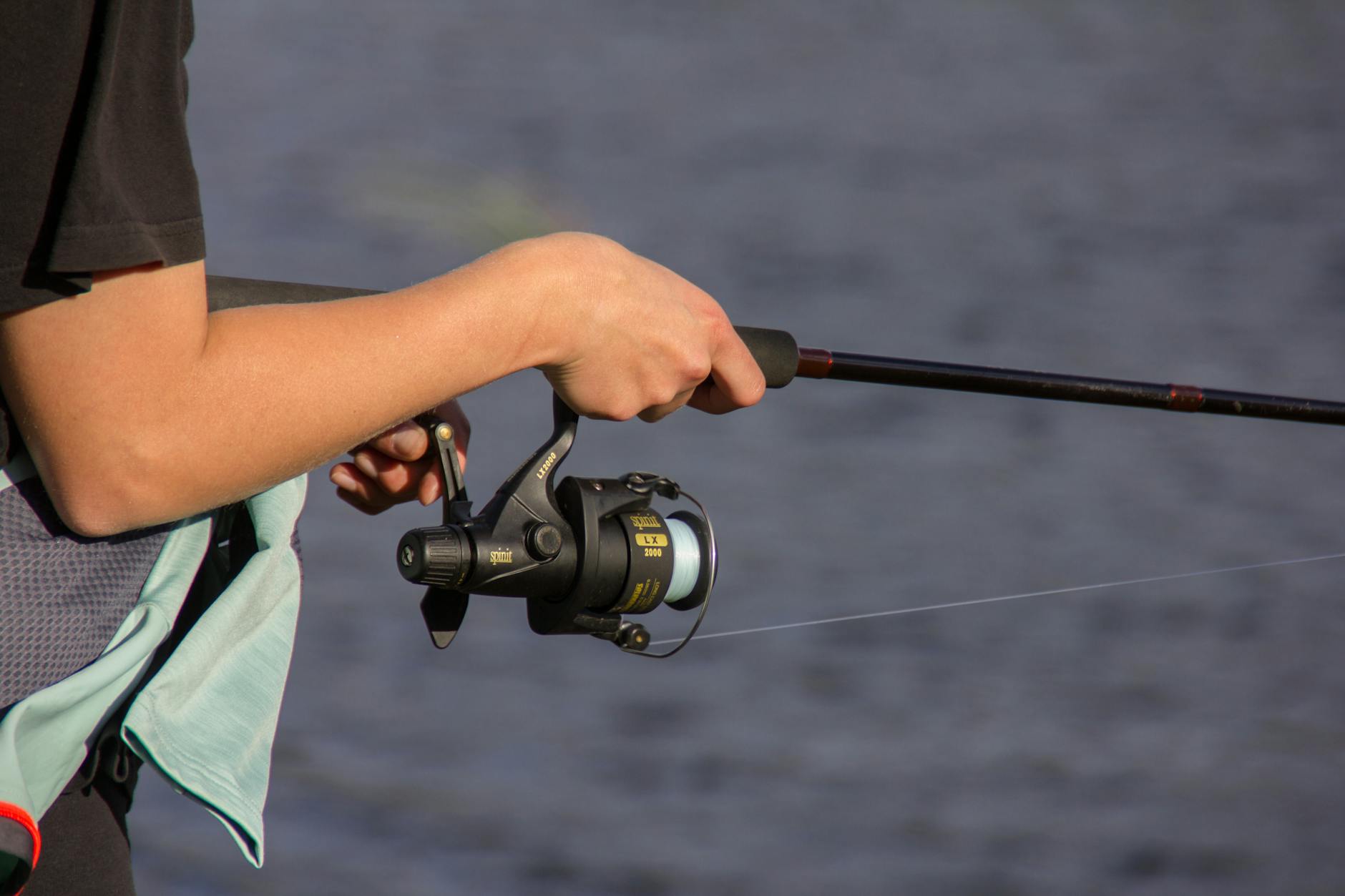 Wędkarz ze spinningiem nad wodą w norweskim Trondheim