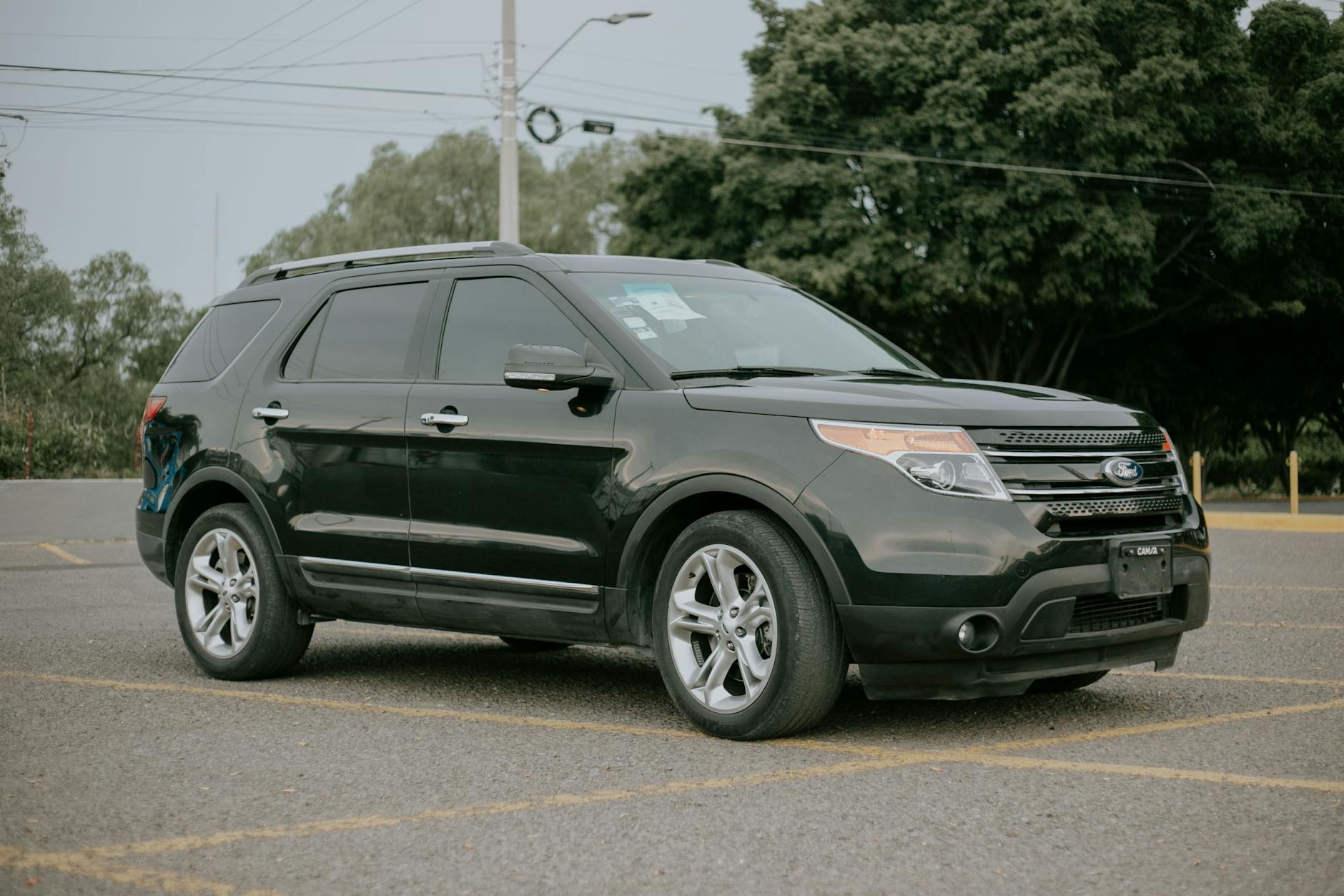 Czarny SUV Mitsubishi Outlander zaparkowany na pustym parkingu