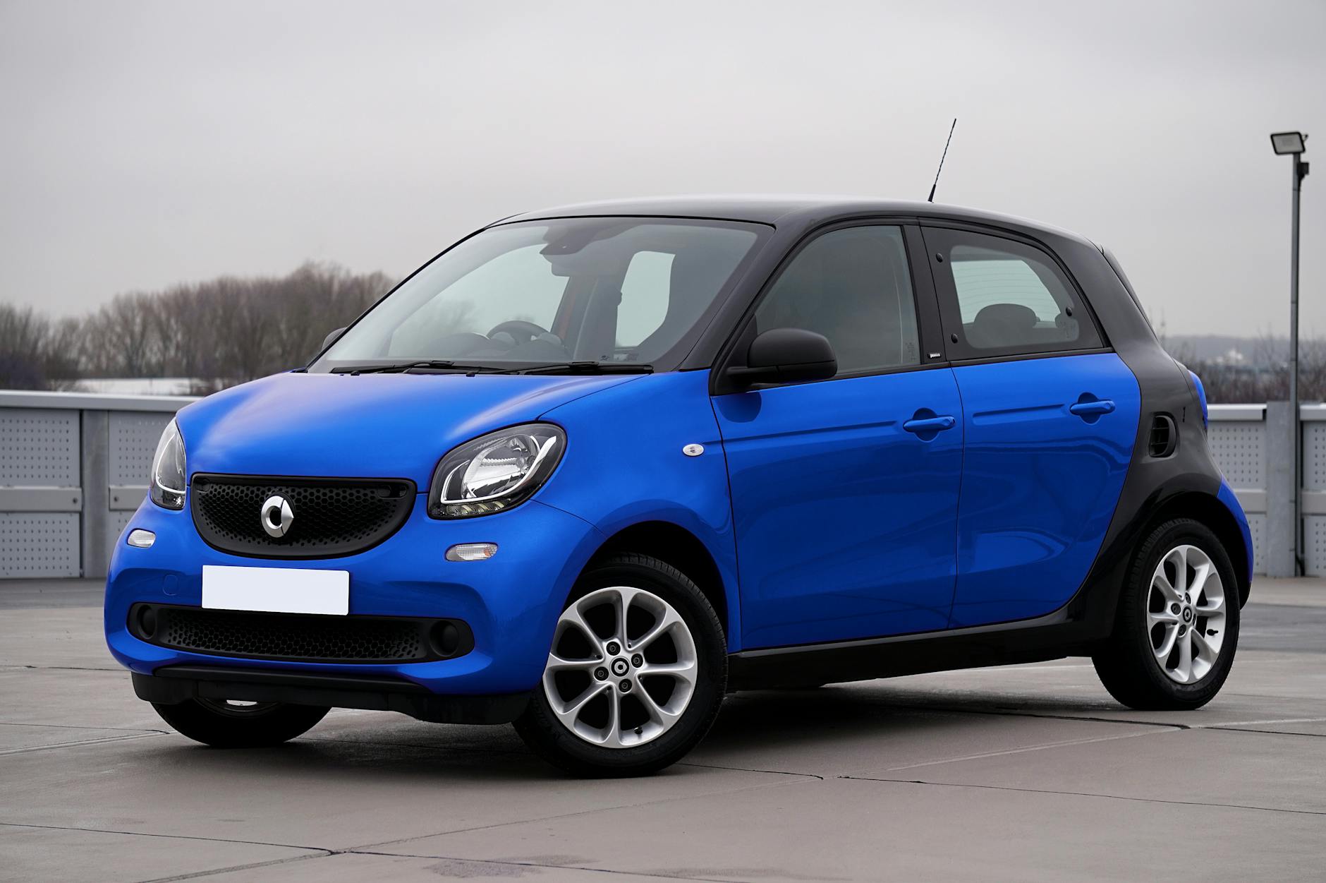 Niebieski Smart Forfour zaparkowany na tle miejskich budynków
