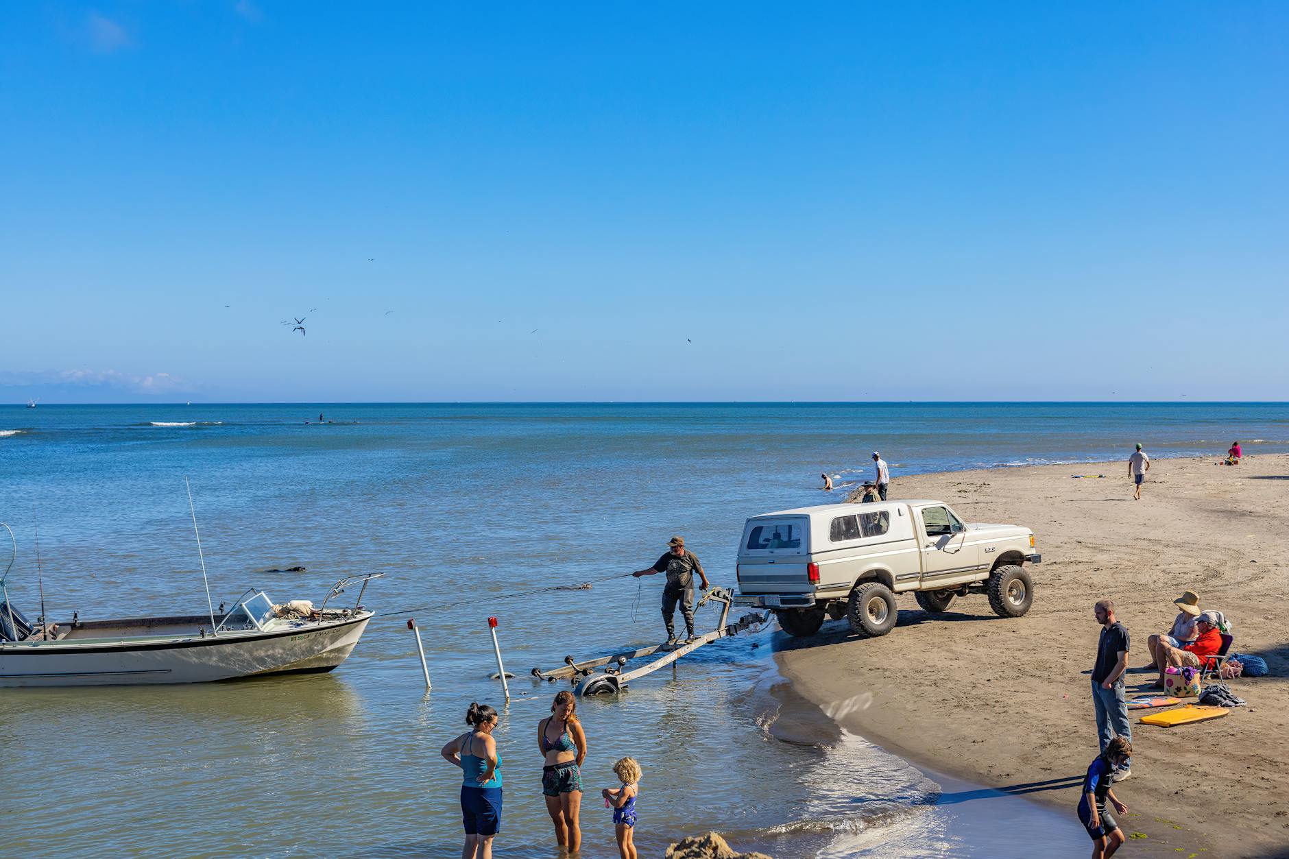 Rodzina na plaży obok pickupa z przyczepą do łodzi