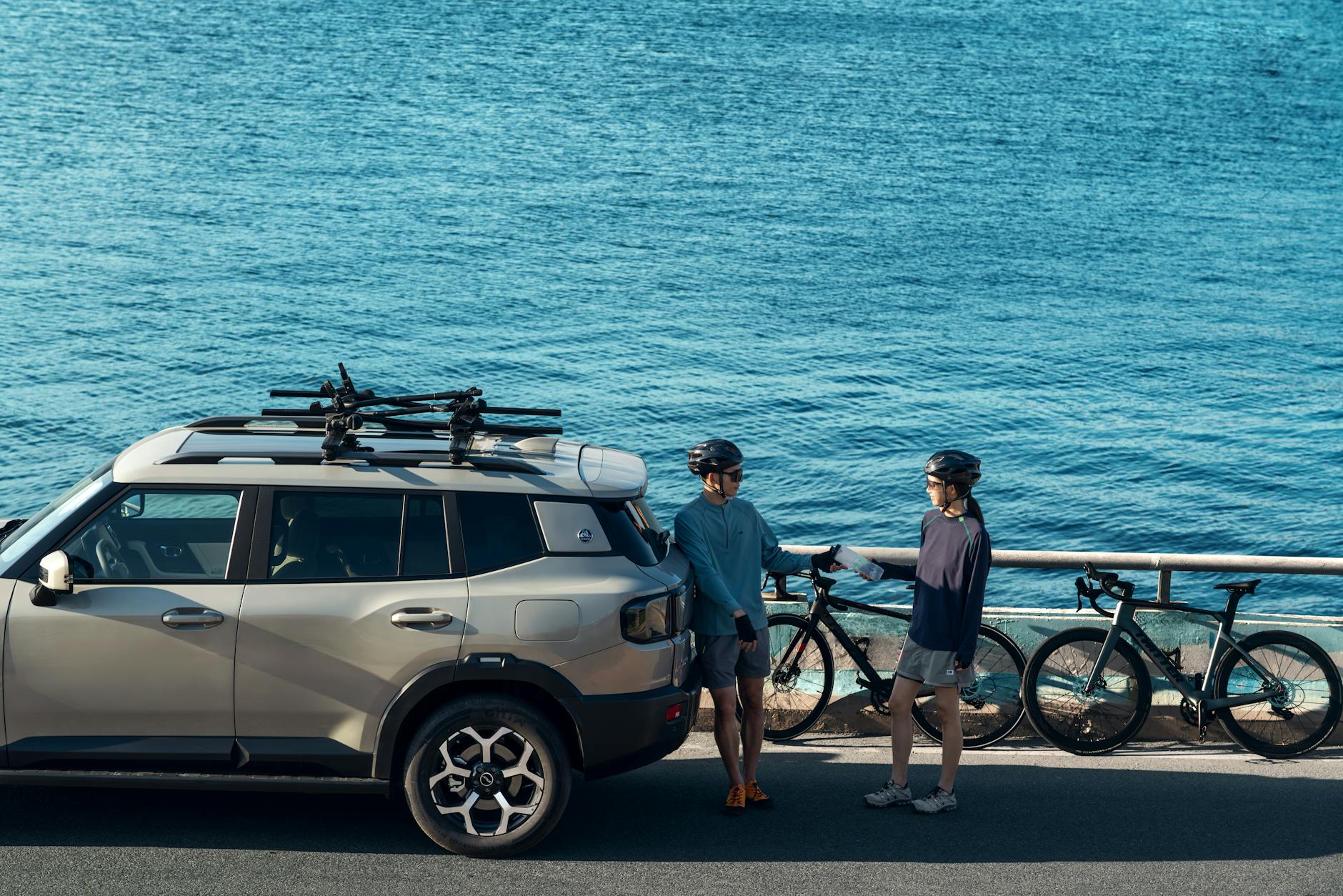 SUV z rowerzystami nad błękitnym oceanem podczas wyprawy
