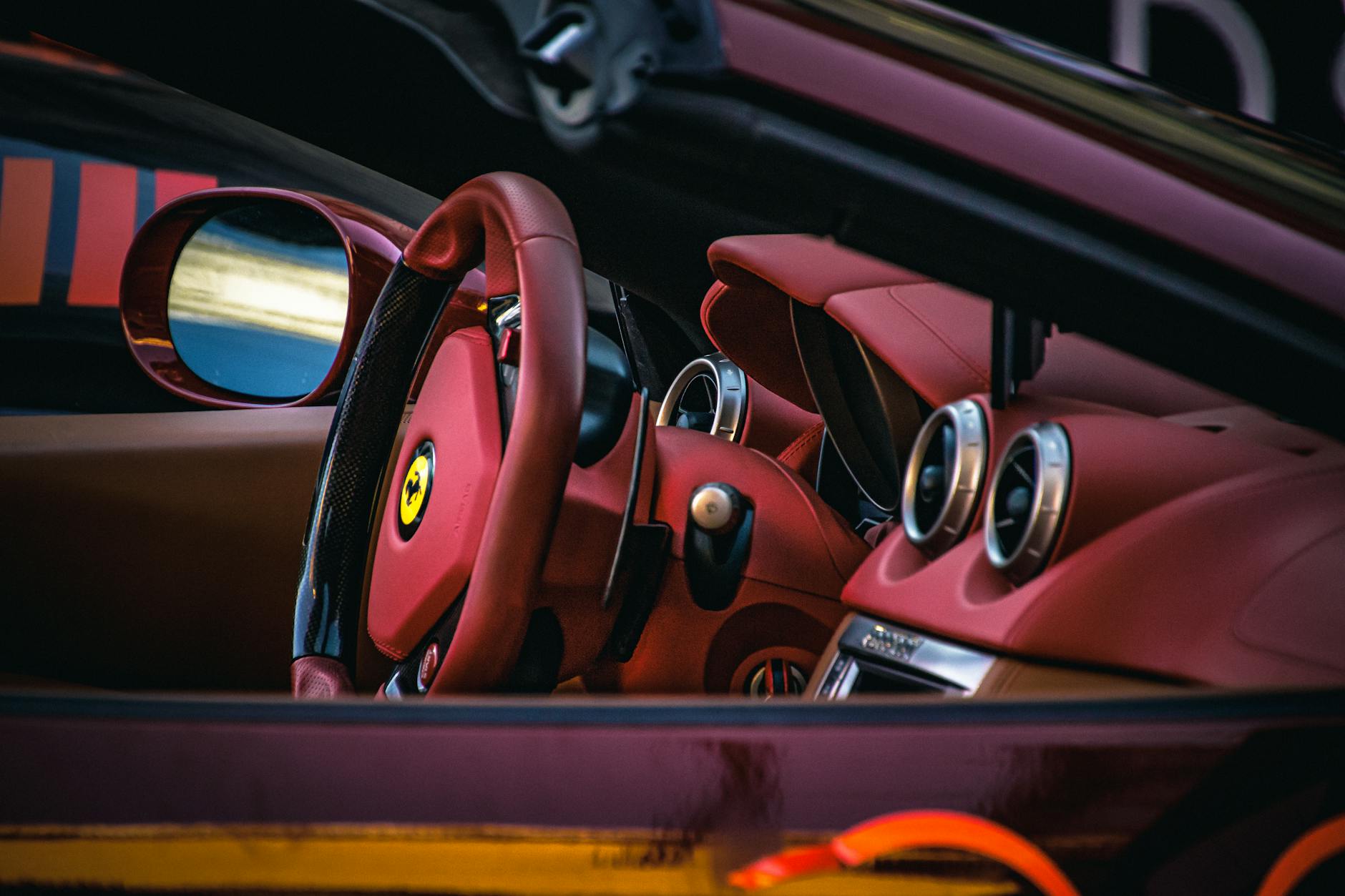 Wnętrze Ferrari Roma z czerwonymi skórzanymi fotelami i kierownicą Wnętrze Ferrari Roma z czerwonymi skórzanymi fotelami i kierownicą