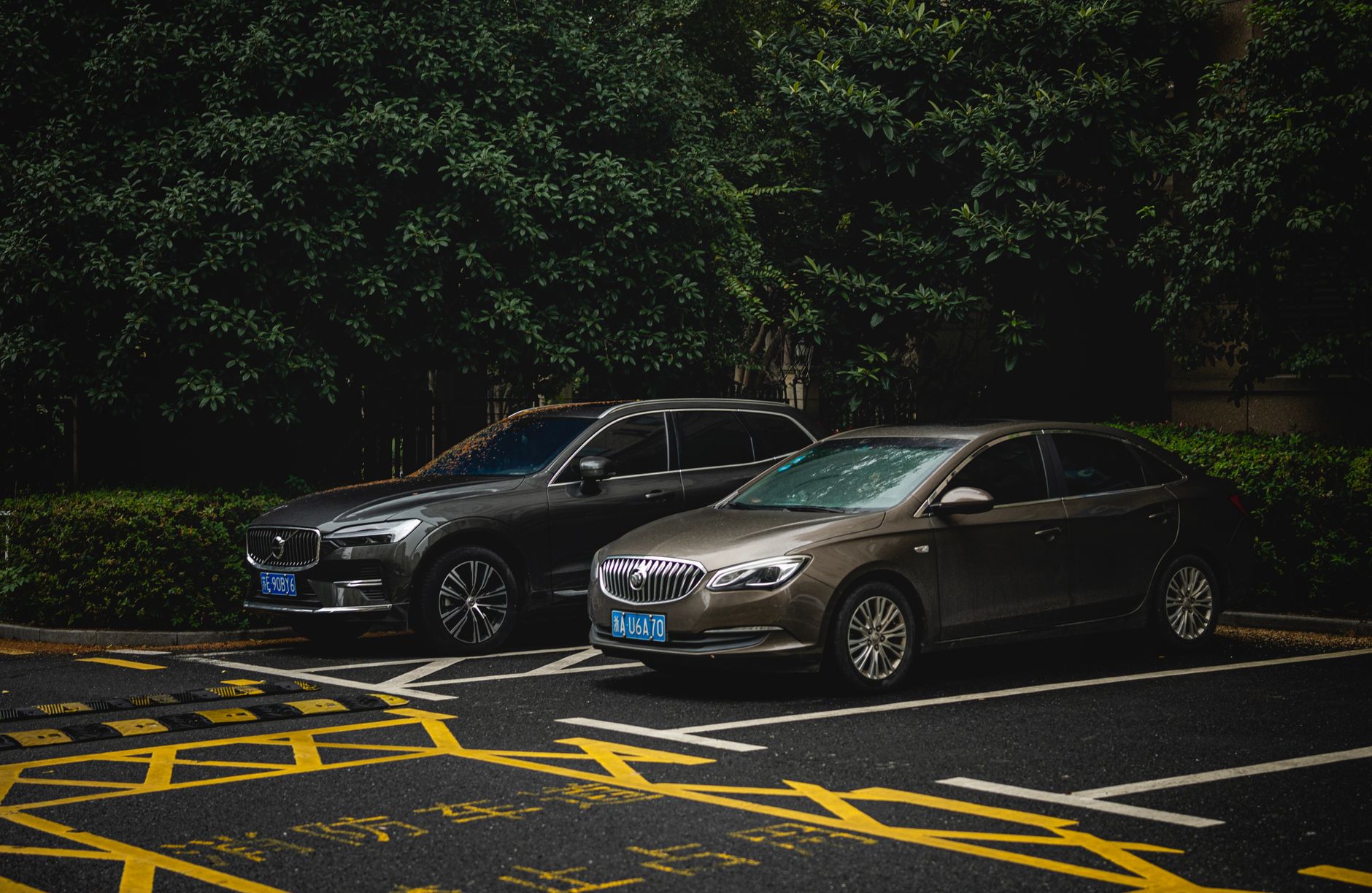 Changan CS55 Plus kontra Kia Sportage i Hyundai Tucson, który SUV opłaca się bardziej SUV i sedan zaparkowane obok siebie na zacienionym miejskim parkingu