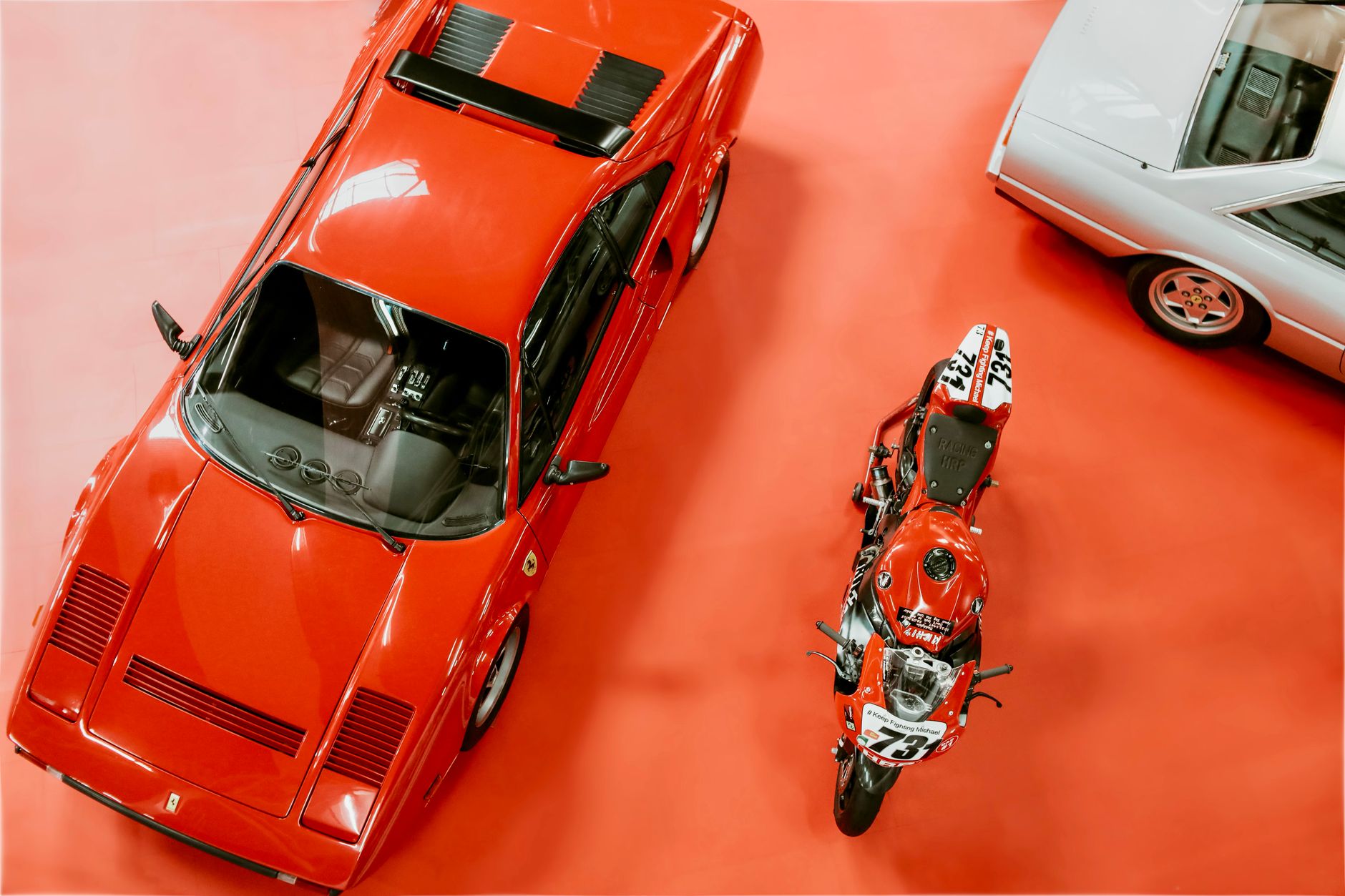 Klasyczne Ferrari i motocykl na wystawie motoryzacyjnej z góry