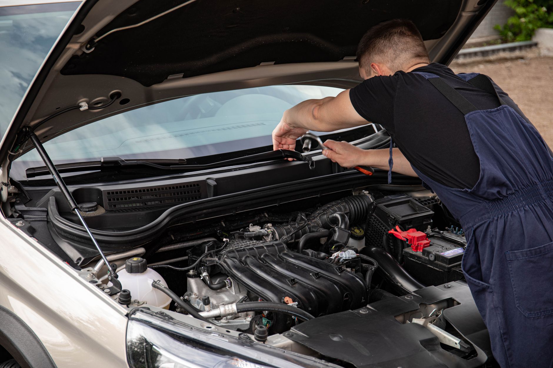 Mechanik naprawia silnik BMW na zewnątrz w świetle dziennym