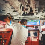 Mechanik pod uniesionym autem w warsztacie samochodowym