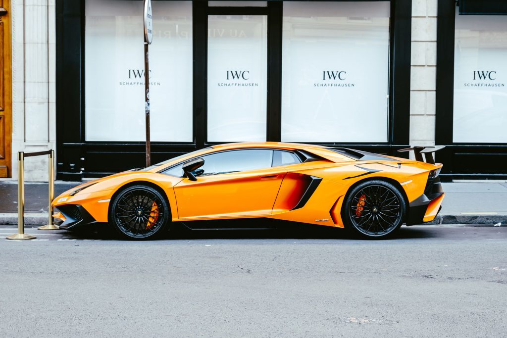 Pomarańczowe Lamborghini Aventador widziane z boku w miejskiej scenerii