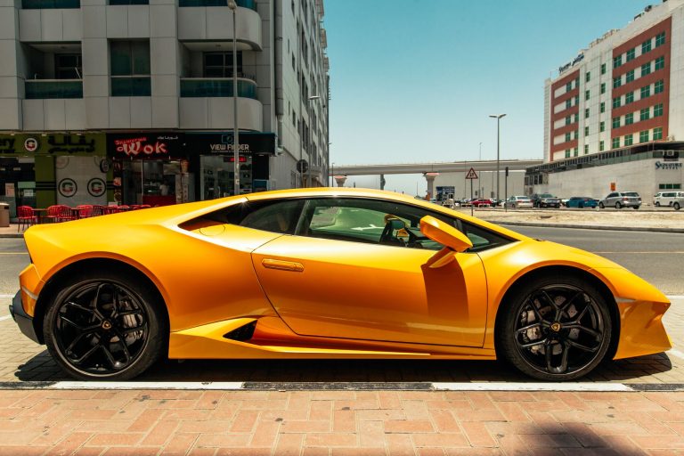 Pomarańczowe Lamborghini zaparkowane na słonecznej ulicy w Dubaju