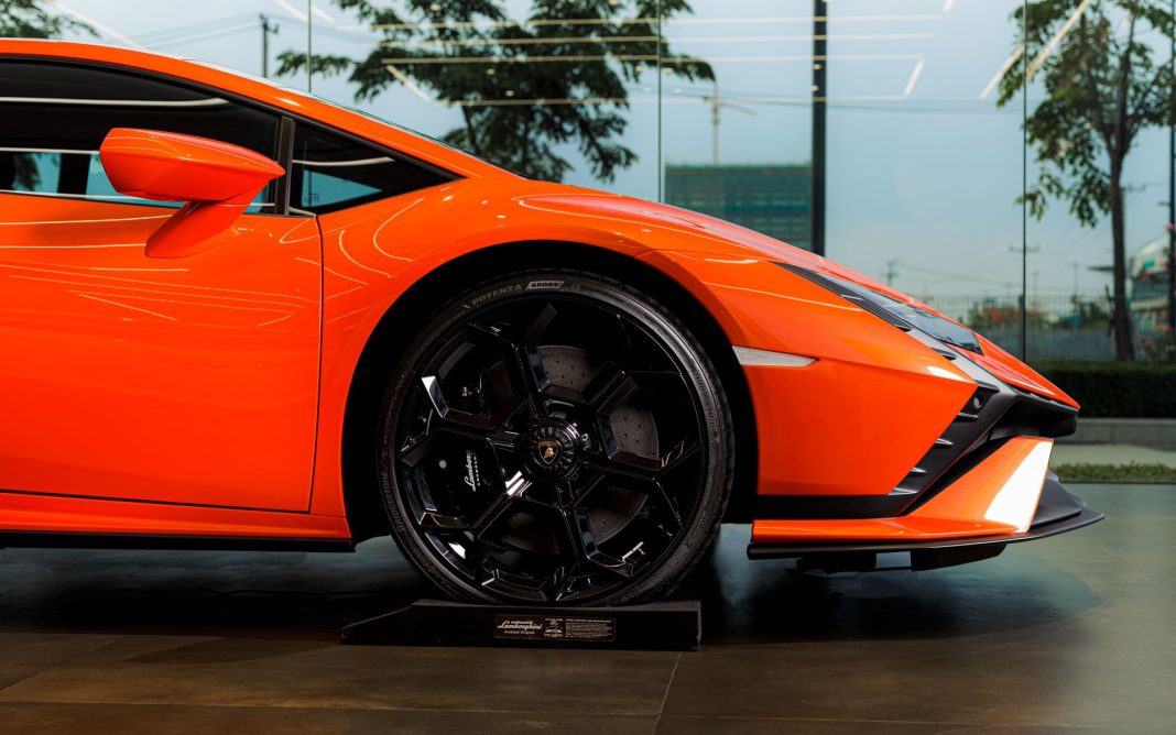Zbliżenie na koło i nadwozie pomarańczowego Lamborghini Huracán Tecnica