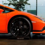 Zbliżenie na koło i nadwozie pomarańczowego Lamborghini Huracán Tecnica